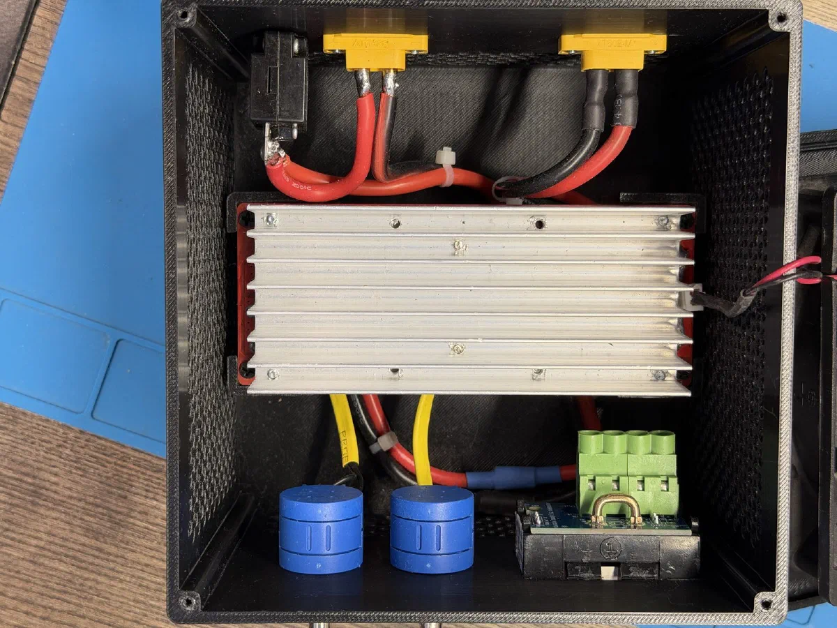 Inside: module on its heatsink, XT60s and breaker at the top, potentiometers and meter at the bottom